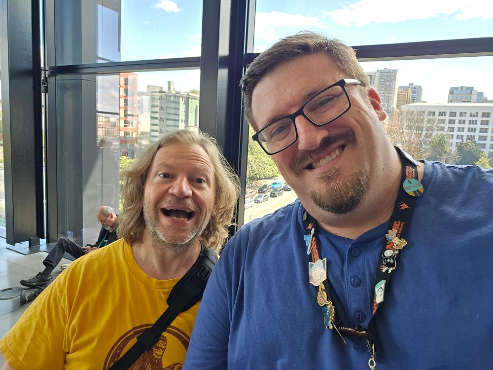 Two person ussie with Brian smiling silly in a yellow shirt and me smiling normal in a blue shirt. 