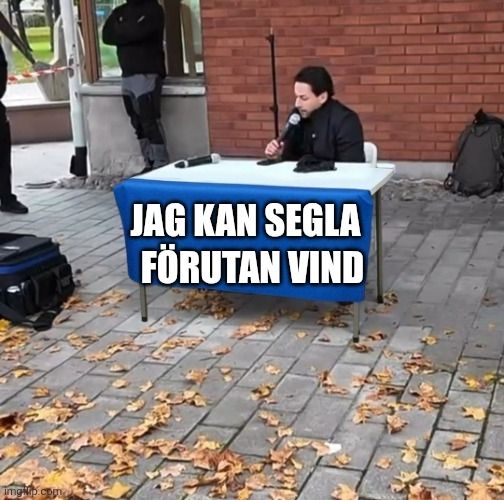 Högerextrema och inte särskilt långa opinionsbildaren Nick Alinia sitter vid ett ganska deppigt bord omgiven av löv och sorg. Bordet har en tygbit där det står "JAG KAN SEGLA FÖRUTAN VIND"