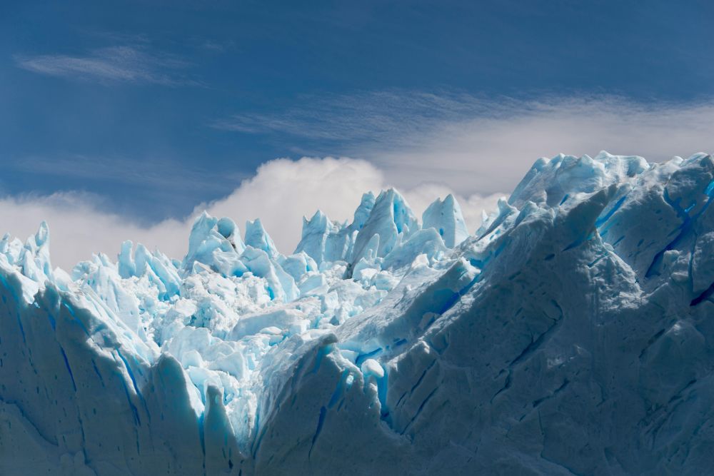 A photo by D. Ovsyannikov / pexels.com shows huge chunks of ice from a calving glacier against a blue sky.