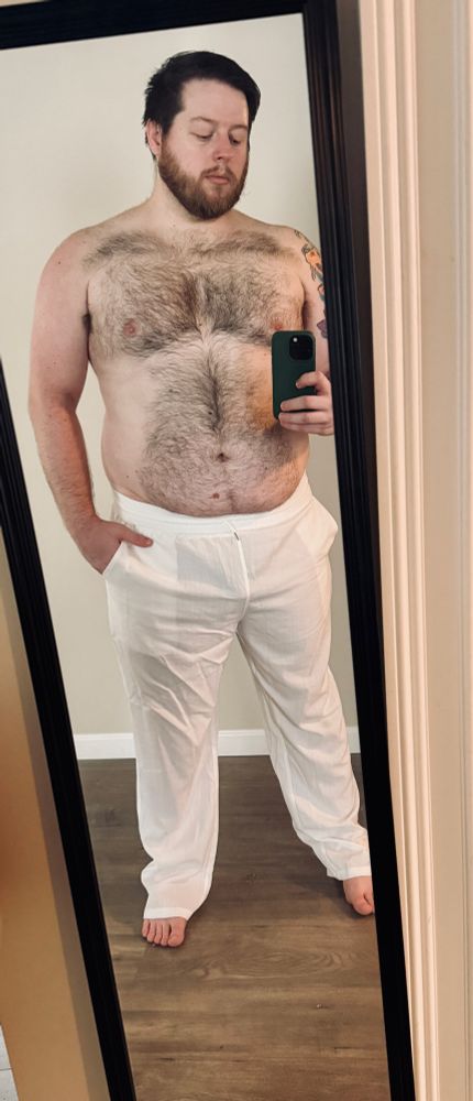 mirror selfie without a shirt on and long white pants 