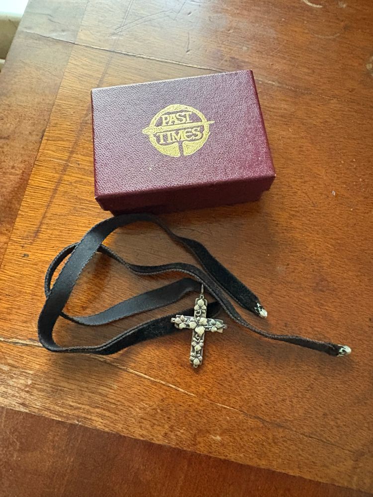 A silver gothic cross on a velvet ribbon, still with the Past Times box it came in.