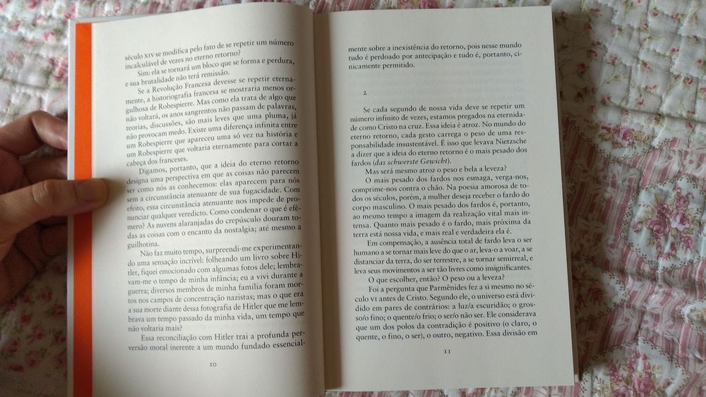 livro "A insustentável leveza do ser" de Milan Kundera aberto, onde se destaca o trecho: 
"Se a Revolução Francesa devesse se repetir eternamente, a historiografia francesa se mostraria menos orgulhosa de Robespierre. Mas como ela trata de algo que não voltará, os anos sangrentos não passam de palavras, teorias, discussões, são mais leves que uma pluma, já não provocam medo. Existe uma diferença infinita entre um Robespierre que apareceu uma só vez na história e um Robespierre que voltaria eternamente para cortar a cabeça dos franceses.
Digamos, portanto, que a idéia do eterno retorno designa uma perspectiva em que as coisas não parecem ser como nós as conhecemos: elas aparecem para nós sem a circunstância atenuante de sua fugacidade. Com efeito, essa circunstância atenuante nos impede de pronunciar qualquer veredicto. Como condenar o que é efêmero? As nuvens alaranjadas do crepúsculo douram todas as coisas com o encanto da nostalgia; até mesmo a guilhotina.
Não faz muito tempo, surpreendi-me experimentando uma sensação incrível: folheando um livro sobre Hitler, fiquei emocionado com algumas fotos dele; lembravam-me o tempo de minha infância; eu a vivi durante a guerra; diversos membros de minha família foram mortos nos campos de concentração nazistas; mas o que era a sua morte diante dessa fotografia de Hitler que me lembrava um tempo passado da minha vida, um tempo que não voltaria mais?
Essa reconciliação com Hitler trai a profunda perversão moral inerente a um mundo fundado essencialmente sobre a inexistência do retorno, pois nesse mundo tudo é perdoado por antecipação e tudo é, portanto, cinicamente permitido."