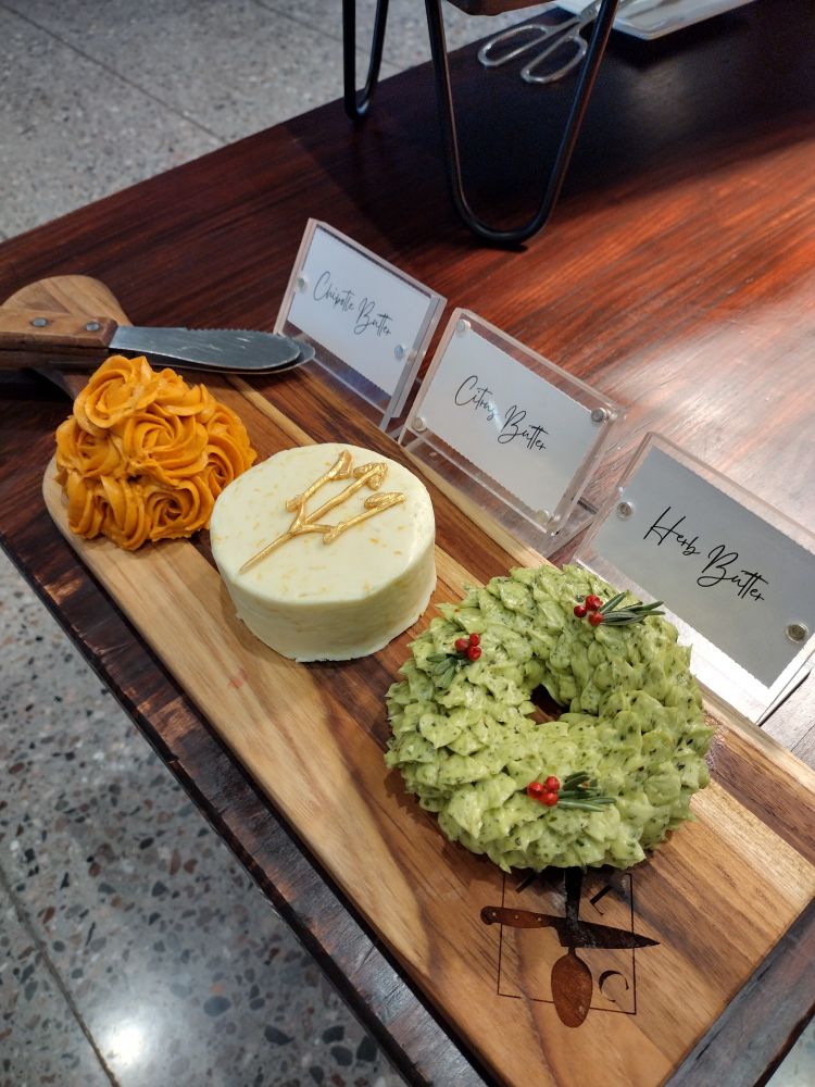 Three very fancy flavored butters on a buffet.

