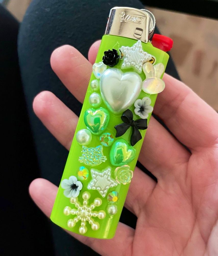 neon green lighter decorated in white and black charms 