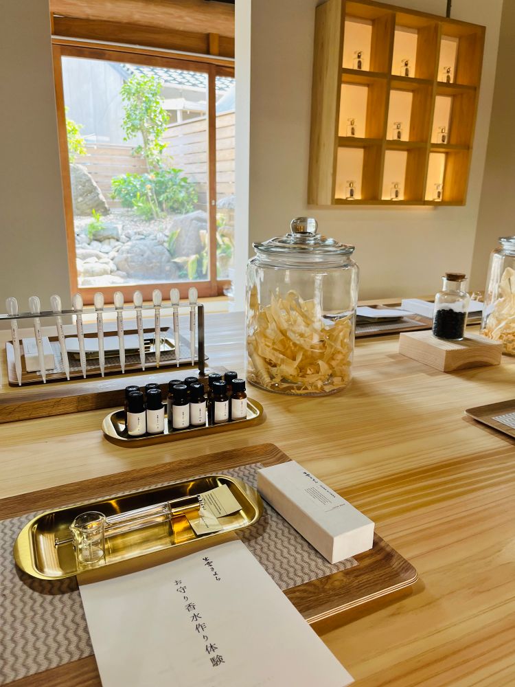 出雲きよらさんのお守り香水作り体験、開始前のセッティング席
木のトレーに金の小さなトレーに小さなビーカーと香水ボトルが載っている
後方に、香りが入ったボトルとスポイトが並ぶ