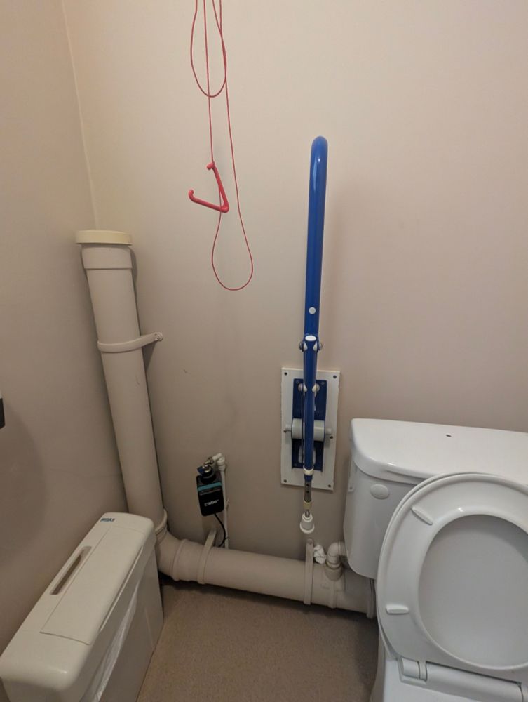 An accessible toilet. The emergency cord is tied up high rather than reaching the floor 