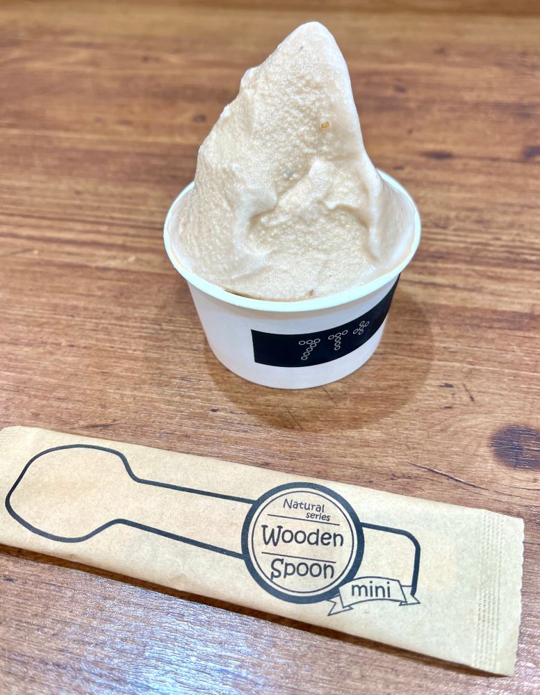 7T＋の普洱茶と柑橘のジェラート。カップに入った薄茶色のジェラートの手前に使い捨てスプーン。