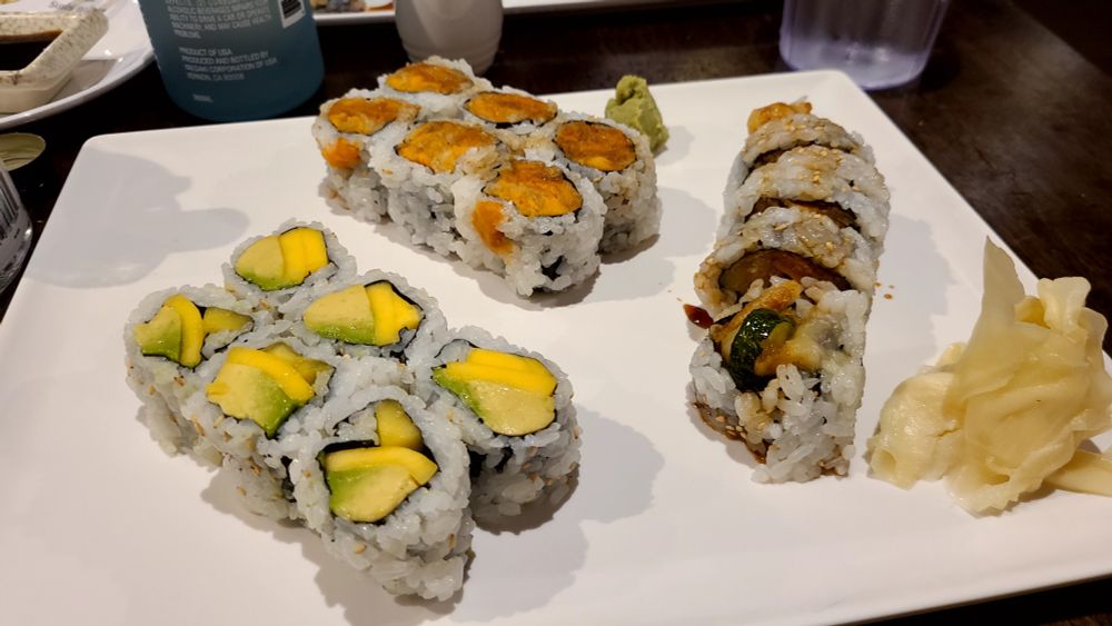 A photo of a variety of vegetable based sushi on a platter.