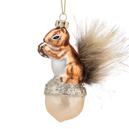 A metalic copper-coloured squirrel ornament with a white belly. The squirrel has a furry tail and is standing on a white acorn .