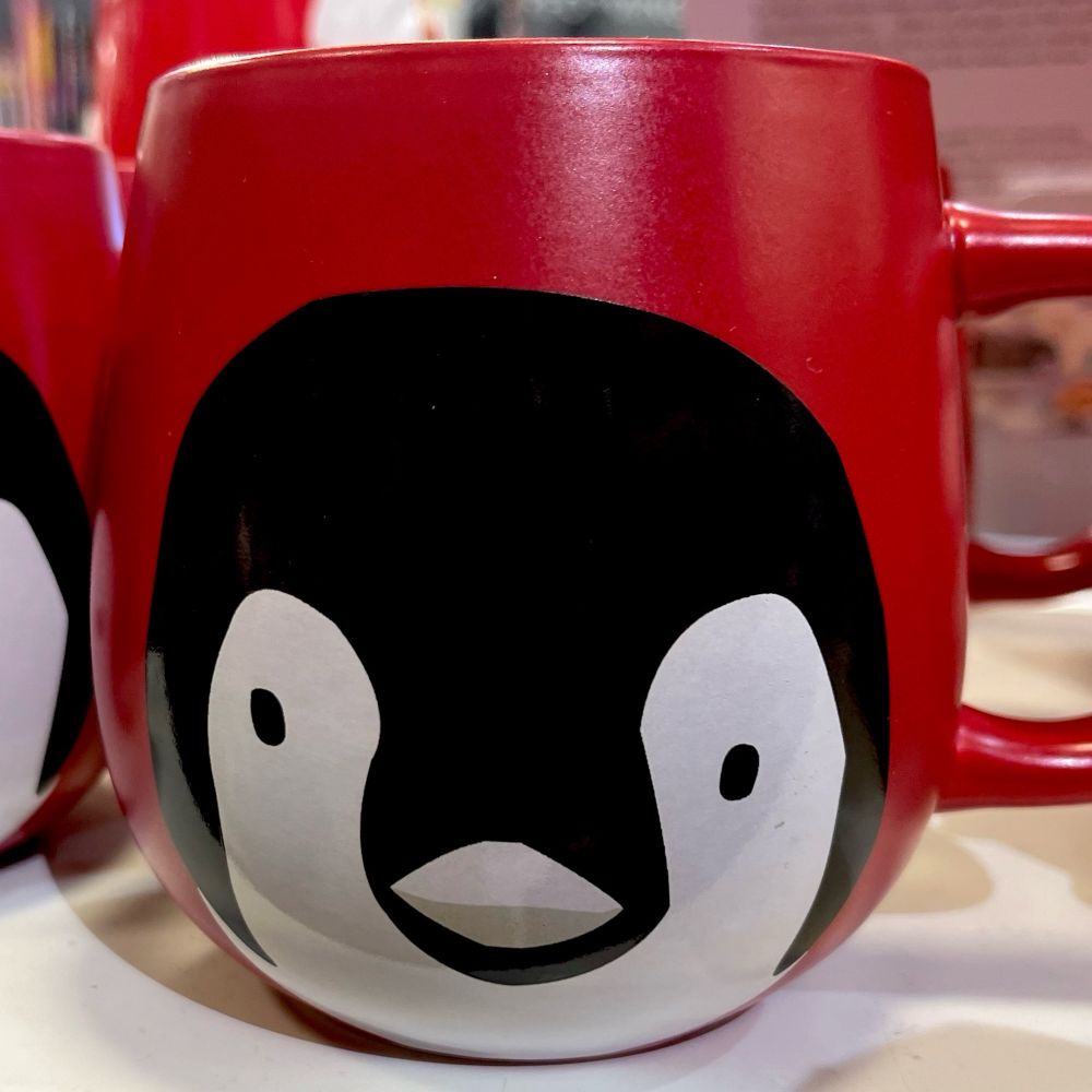 A stylized penguin mug with a red background 