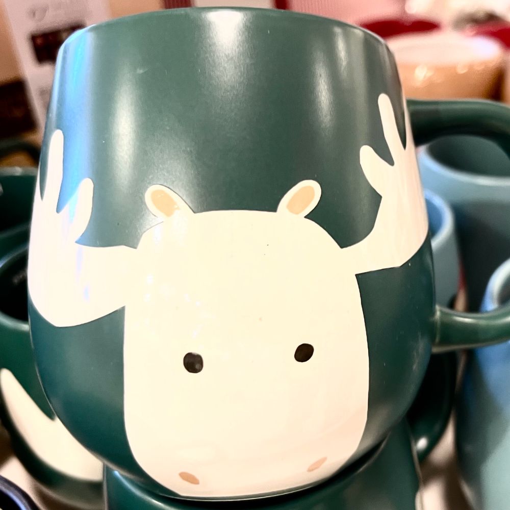 A stylized reindeer mug with a green background 