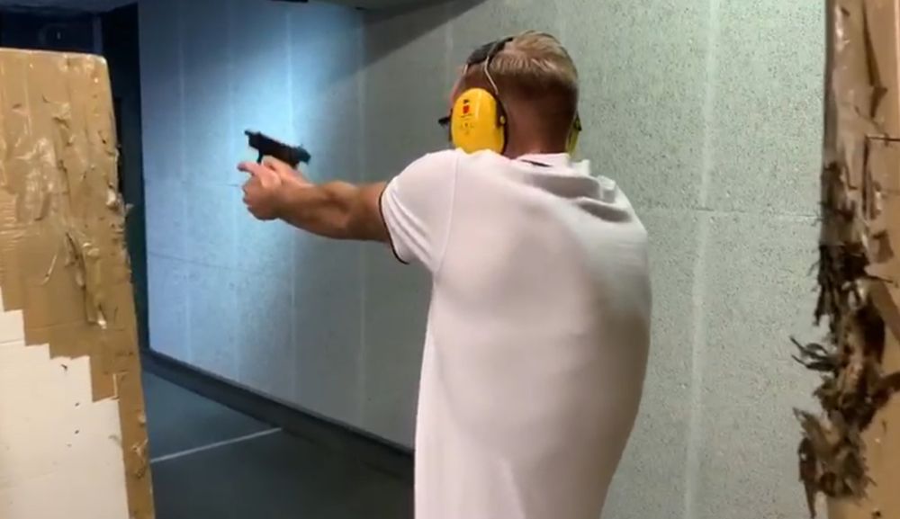 Foto von mir im weißen polo auf einem Schießstand. Die Rückenmuskulatur zeichnet sich leicht ab.