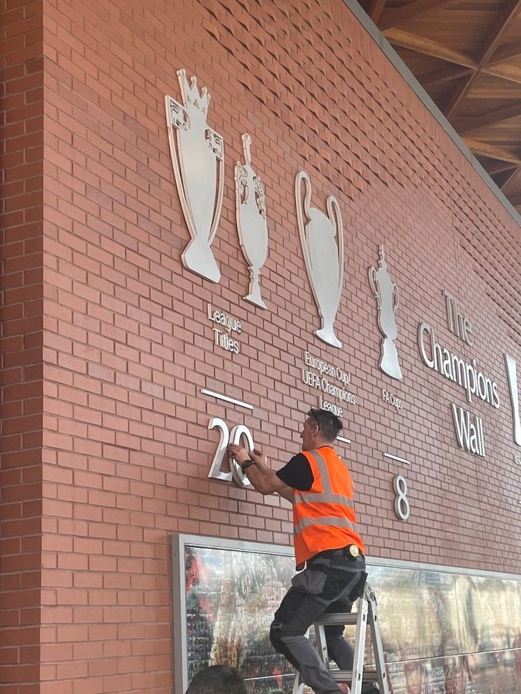 Workman installing the number 20 under league titles outside Anfield this morning.
