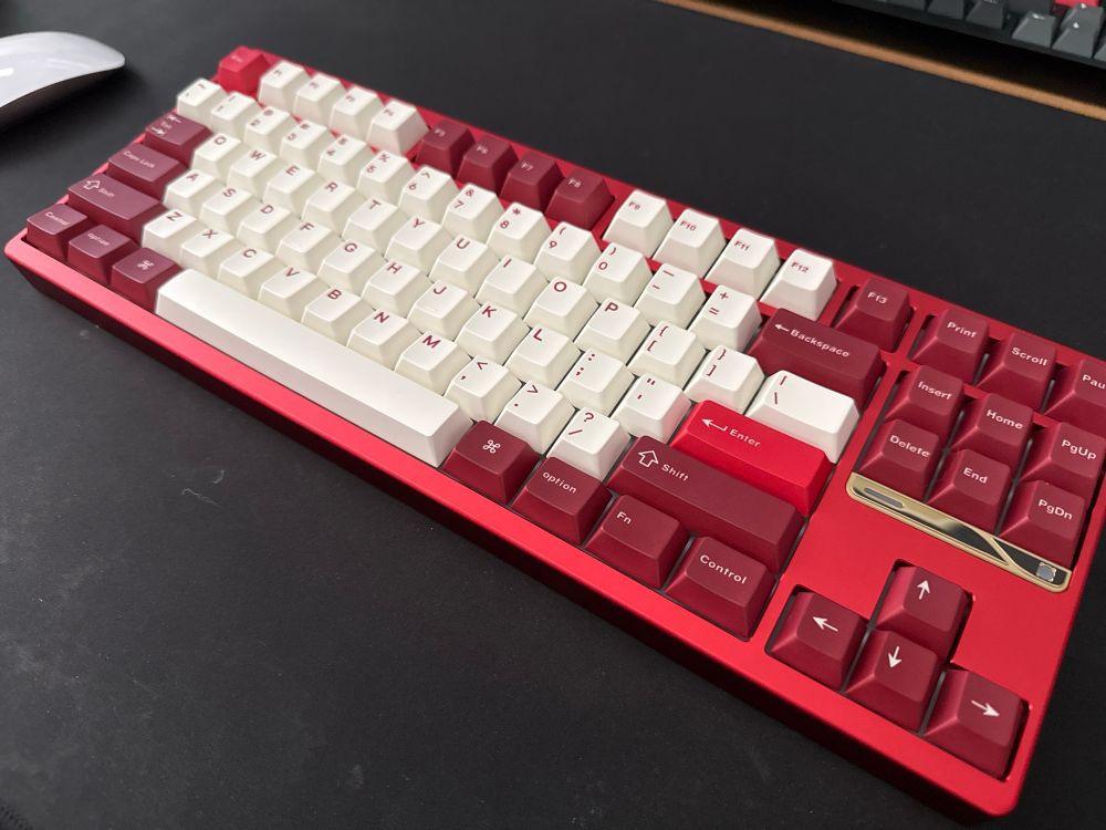 A red mechanical keyboard with dark red and white keycaps.