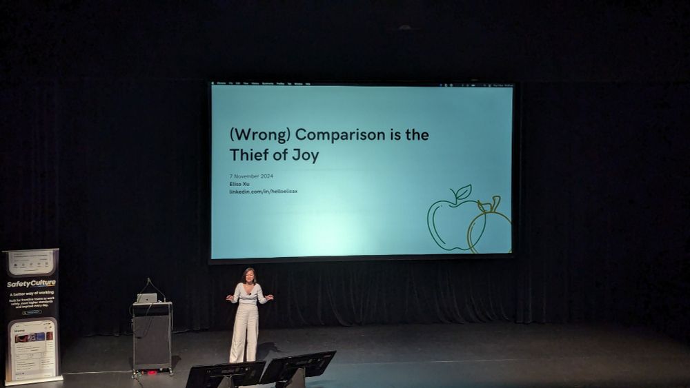 A photo of Elisa Xu in front of her title slide for her talk