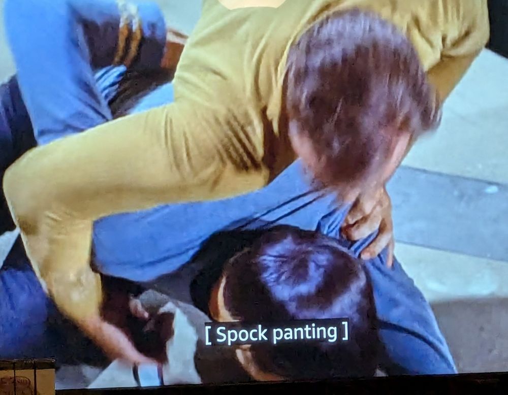 Shot of TOS episode "Operation Annihilate" where Kirk is on top of Spock's back, holding onto him aggressively, and the caption reads "[Spock panting]"
