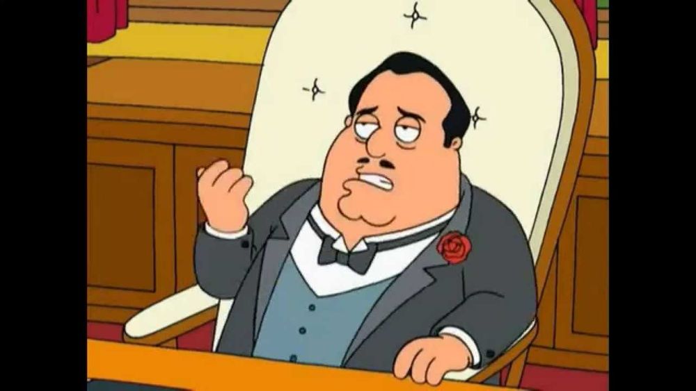 The Don from Family Guy, reclining in a luxurious padded armchair behind a desk.
