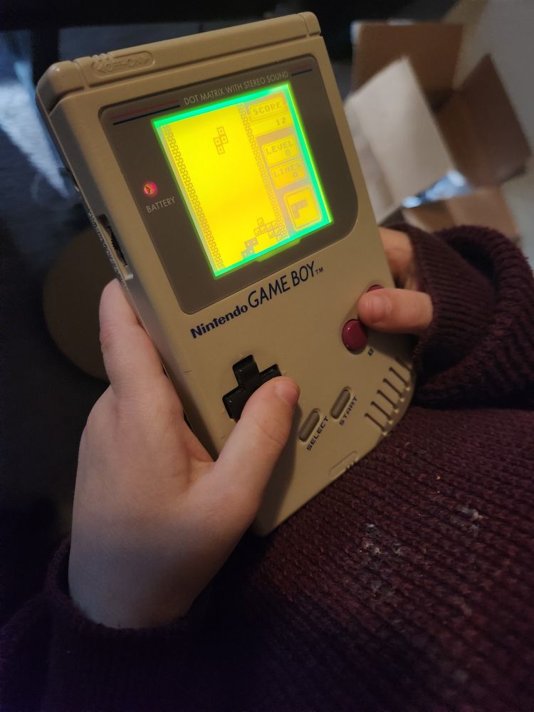 Close-up of child's hands holding a Nintendo Game Boy