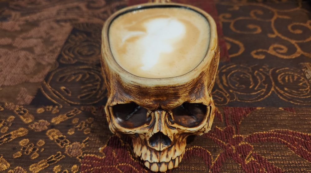 Skull-shaped coffee mug with oatmilk latte