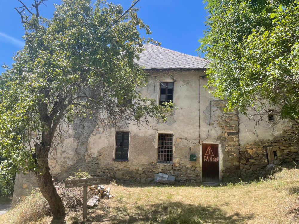 Photo d’une maison délabrée avec deux écriteaux : « la Maison Blanche » et « danger »