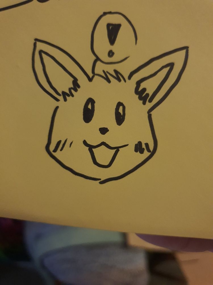 a drawing of the pokemon eevee in felt pen, on a yellow sticky note. It is happy and a speech bubble is over it's head, with an exclamation point inside. 