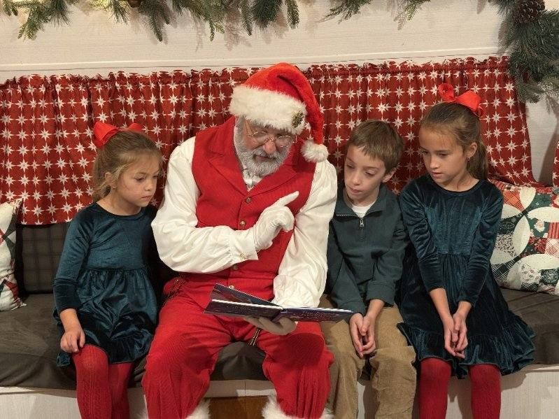 Santa on camper bench reading to kids