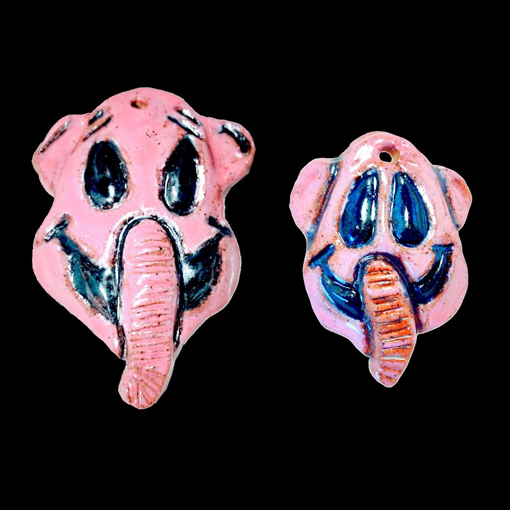 Two small ceramic elephant masks/pendants/trinkets. Inspired by the Pink Elephants on Parade scene from Dumbo.