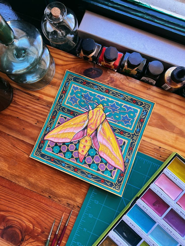 A gouache and watercolor painting on a square piece of archival paper. The painting features an elephant hawk moth, a bright yellow, olive and pink moth, against a background pattern of bold colors and gold inspired by illuminated medieval manuscripts. 