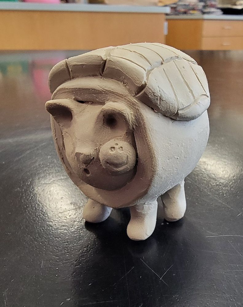 Small clay sculpture of a cutified one eyed dog rolled in a sushi roll.