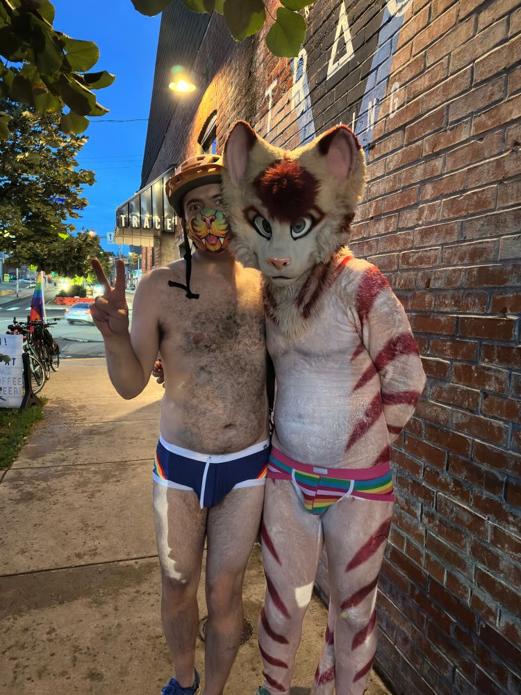 photo of me in skimpy swimshorts and a stablercake sabertooth mask & Manich dressed in his petsuit & rainbow undies after cycling on the Pittsburgh Undie Ride