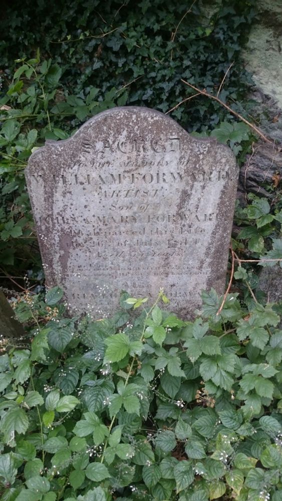 Aged gravestone surrounded by brambles and ivy.