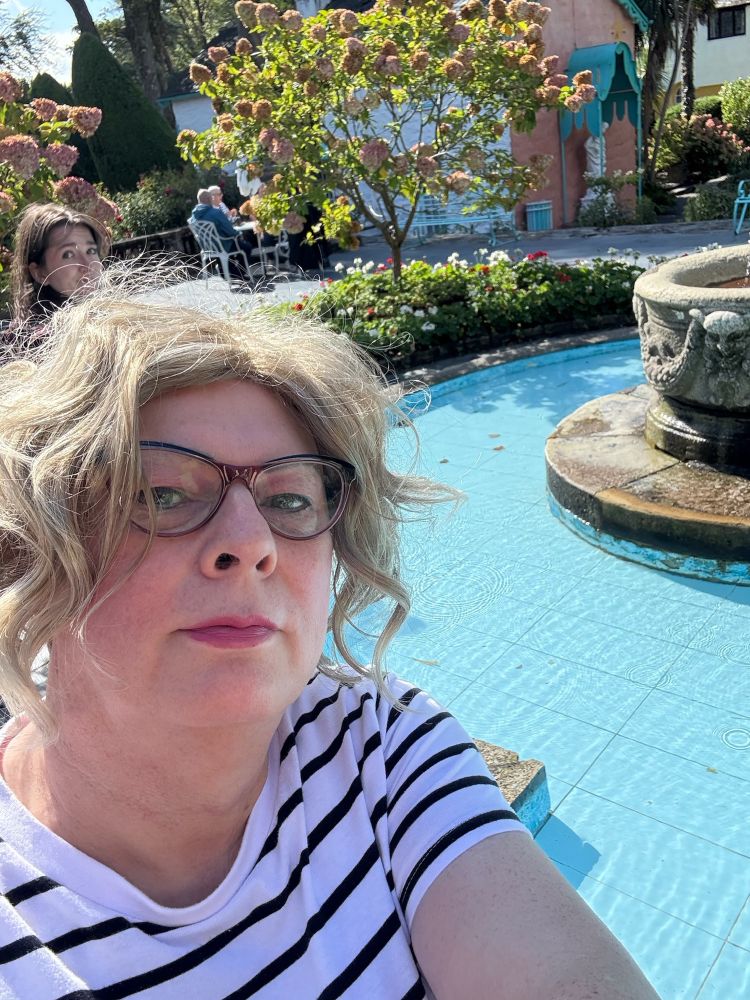blonde woman in front of a fountain pool