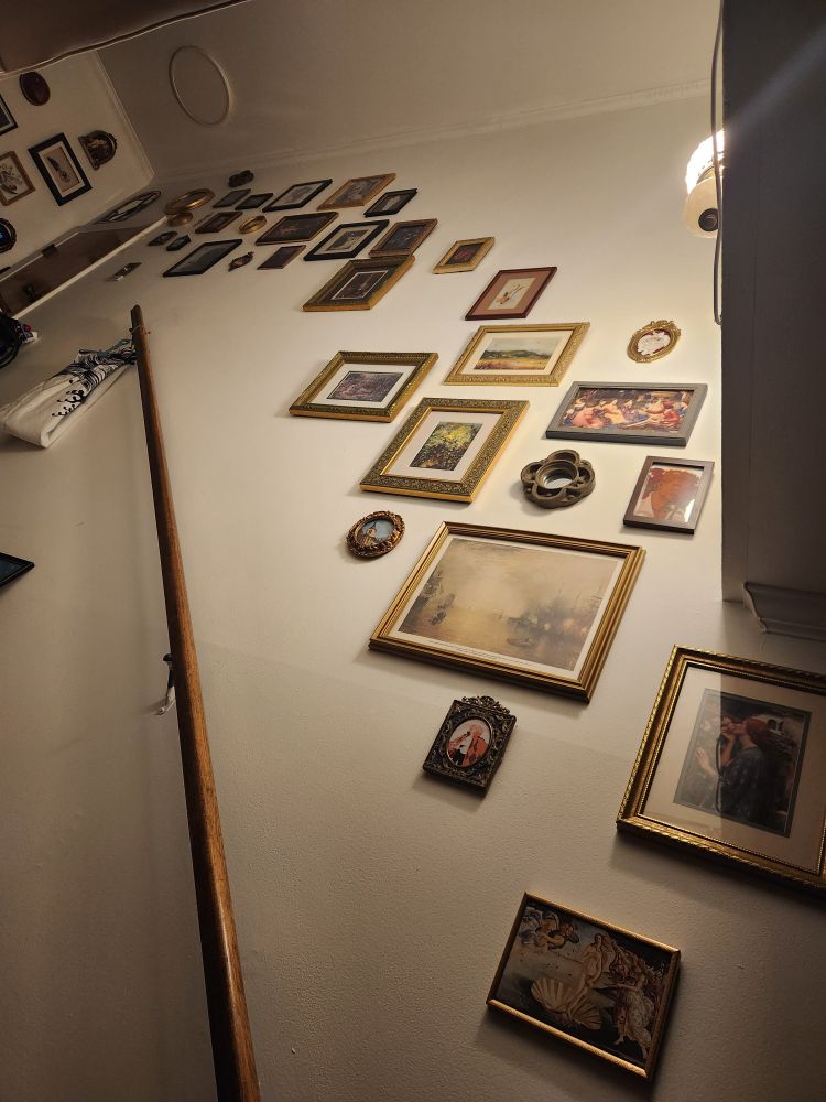 A janky shot pointed up the stairs, focused on the side wall. A very involved art gallery is taking shape: there are still gaps, but so far there are something like 30 pieces hung.