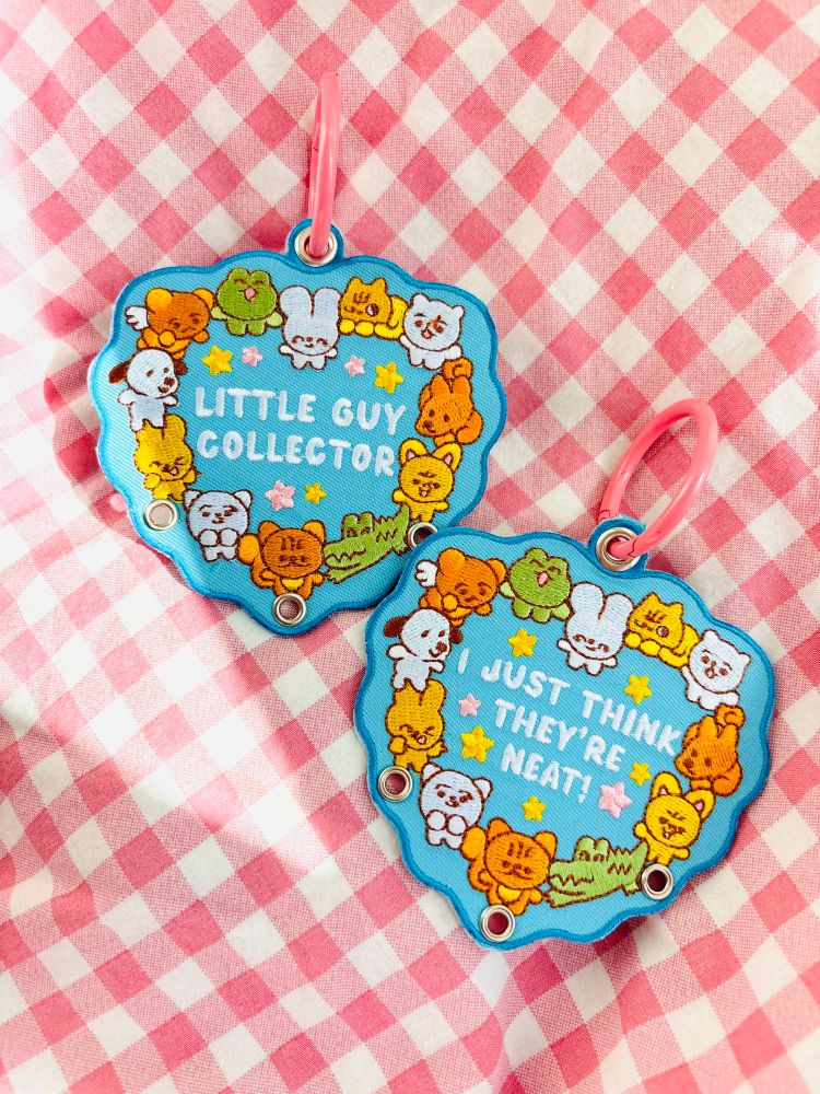 Photo of embroidered keychain that reads “little guy collector” on one side and “I just think they’re neat” on the other 
