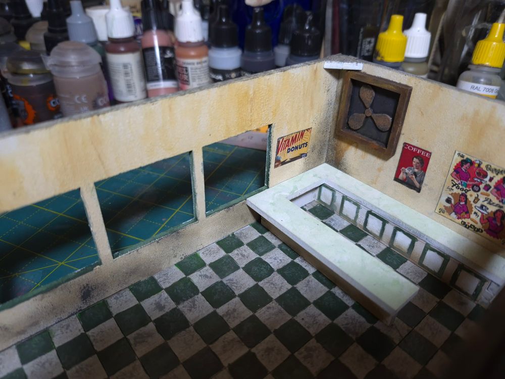 The interior of a 28mm scale miniature diner, painted white and green