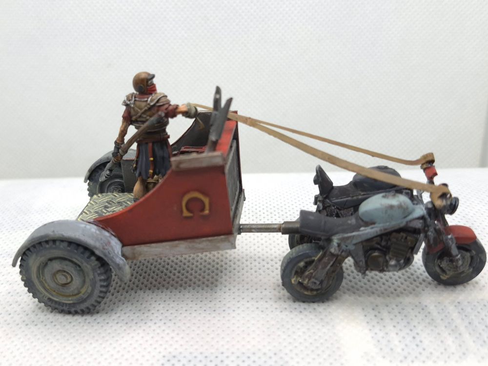 Kitbashed 28mm motorcycle chariot painted red and crewed by a Fallout Caesars Legion Explorer