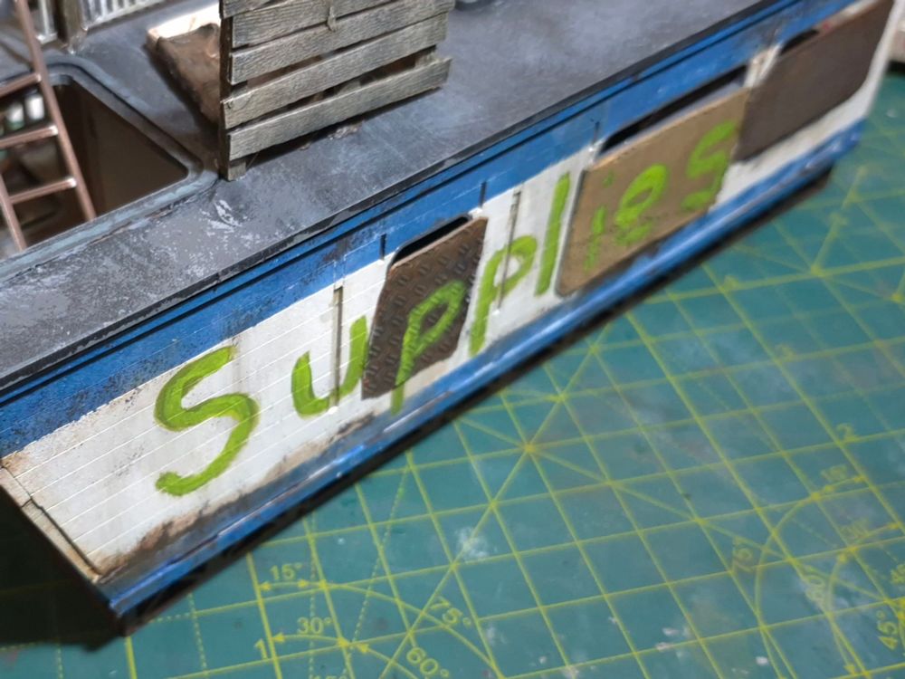 The outside of the residential trailer, the word "Supplies" has been written in large letters in green paint along the side.