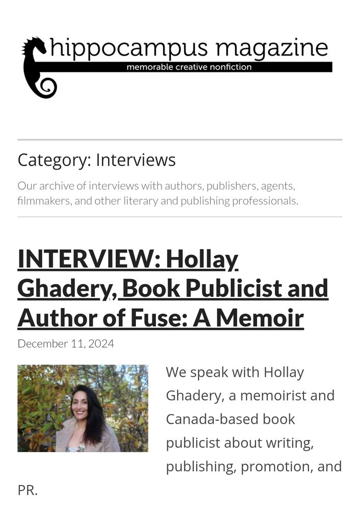 Photo of author with long brown hair standing in front of a tree.