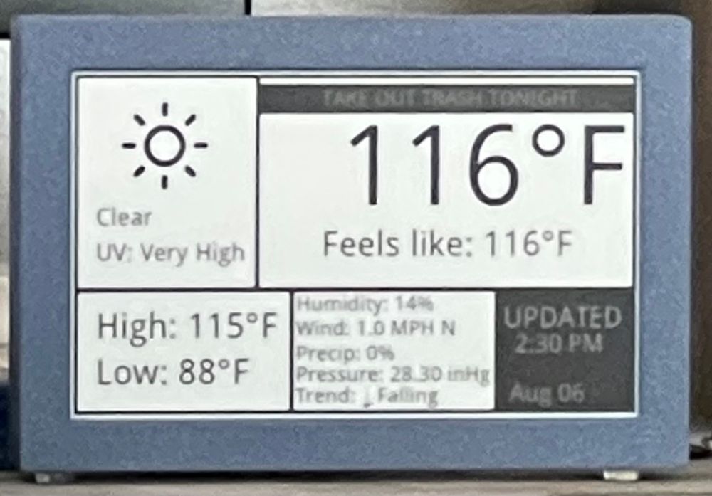 A digital weather display shows extreme heat with a temperature of 116°F (46.7°C), which also feels like 116°F. The sky is clear with a “Very High” UV index. Additional details include a high of 115°F (46.1°C), a low of 88°F (31.1°C), 14% humidity, 1.0 MPH wind from the north, 0% precipitation, a pressure of 28.30 inHg, and a falling trend. The display was last updated at 2:30 PM on August 6, and there’s a reminder at the top that says “TAKE OUT TRASH TONIGHT.”