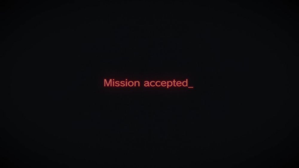 A black screen with red computerized text that reads "Mission accepted_"