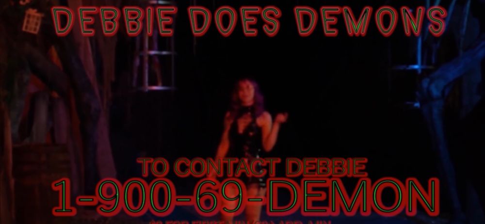 still from the in-movie tv show Debbie Does Demons with the phone number 1-900-69-DEMON