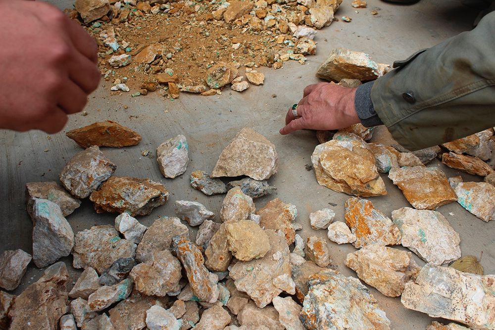 Miners' hands sift through metamorphic rock searching for rare flashes of emerald green crystals (author’s photo).