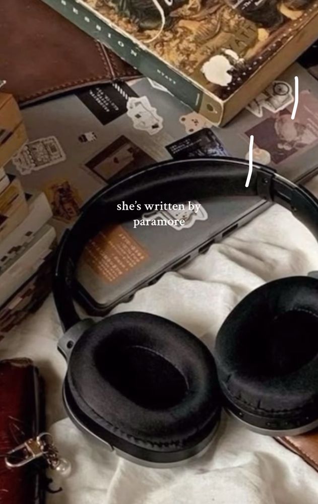 headphones, laptop and clutter with the caption “she’s written by paramore”