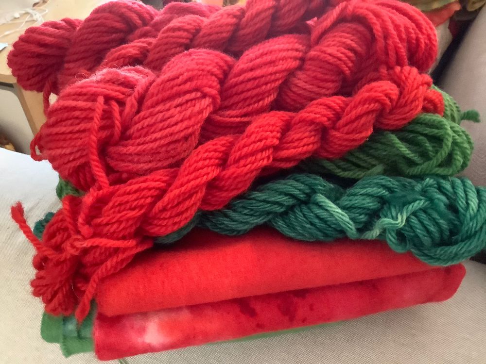 Wool fabric and yarn, hand dyed red and green. Spot dyed green, and red yardage. Also Immersion dyed red, and green, yardage. Yarn, immersion dyed and spot dyed, in red and green. Two types of green: a grass green and a blue green. 