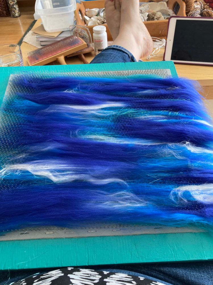 Blue and white fibres creating an art battle on blending board. 