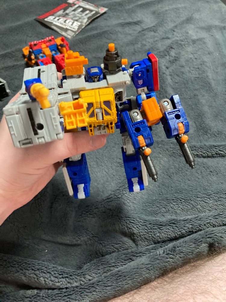 A Transformers fan-mode combiner featuring Earthrise Airwave and Generation Selects Greasepit.