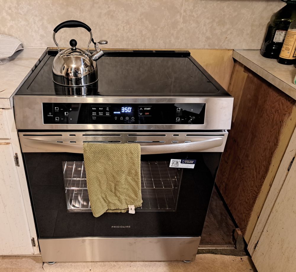 "Before" picture of the range in place, but with a big gap on its right. Also, it's also not level with the countertops.