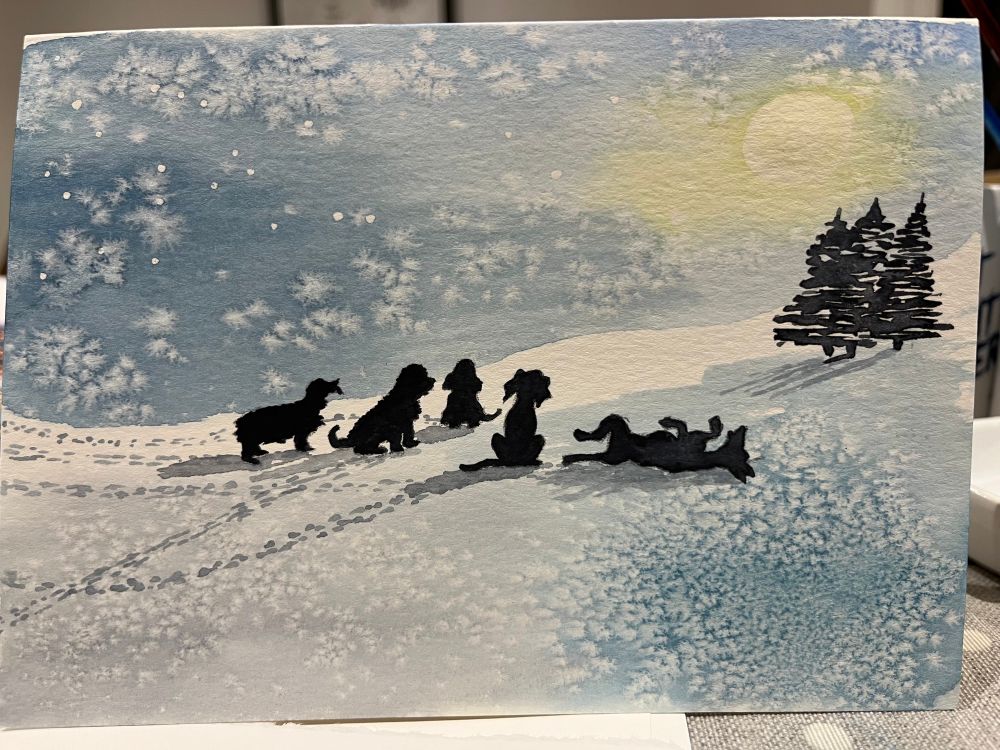 A painted Christmas card using a watercolour and salt effect that looks like ice crystals, picturing 5 dogs on the snow under a bright moon. 