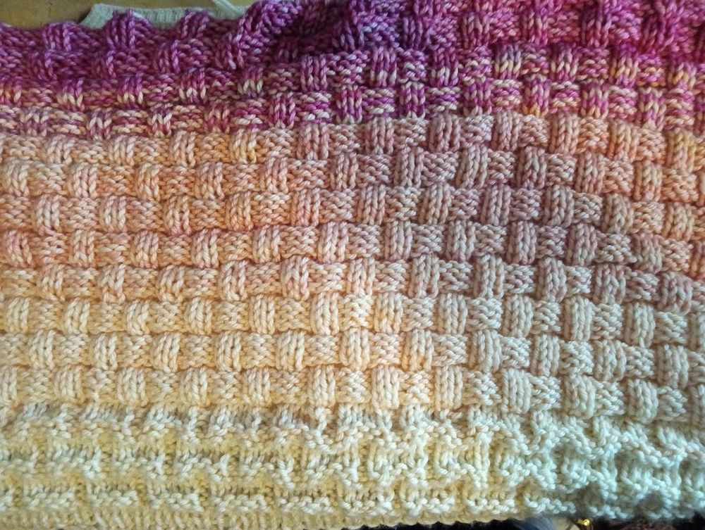 A pink-to-white gradient knitted panel with a basketweave stitch pattern.
