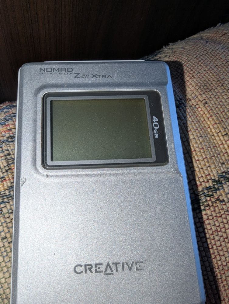 Nomad Jukebox Zen Xtra gray rectangular case with 2 inch screen and 40gb printed vertical on the right side of the screen panel.